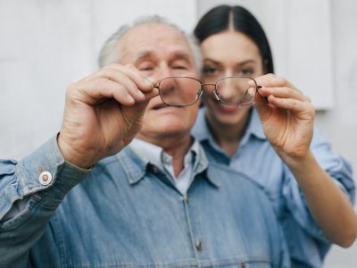 old-man-standing-gray-backround-with-his-granddaughter
